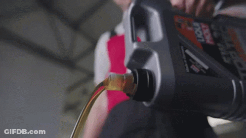 A Bottle Of Oil Is Being Poured Into A Motor GIF
