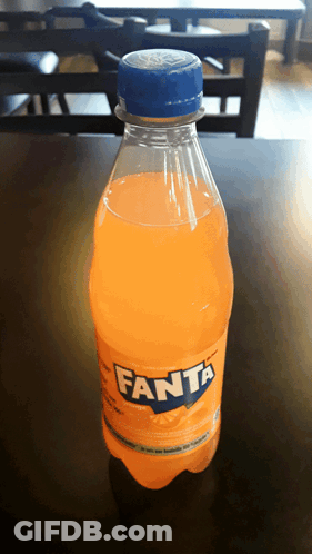 A Bottle Of Orange Fanta Soda On A Table GIF