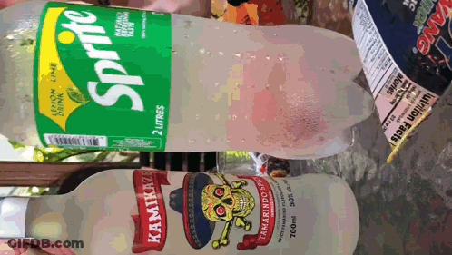 A Bottle Of Sprite Sits Next To A Bottle Of Kamikaze Tamarind Sprit GIF
