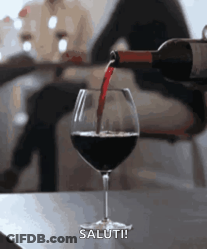 A Bottle Of Wine Is Being Poured Into A Glass With The Words Saluti Written Below It GIF