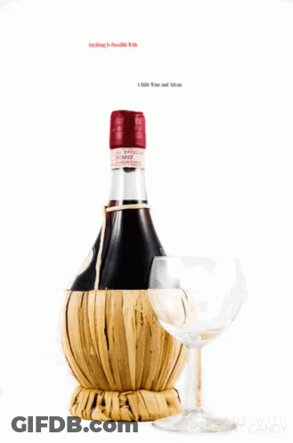 A Bottle Of Wine Is Wrapped In A Wicker Basket Next To A Wine Glass GIF
