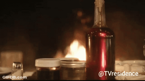 A Bottle Of Wine Sits On A Table In Front Of A Fireplace With The Hashtag @Tvresidence GIF