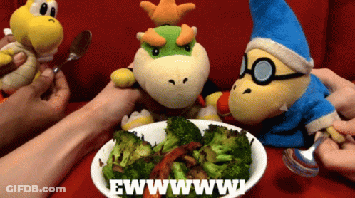 A Bowl Of Broccoli Sits On A Table Next To A Sign That Says Ewww GIF