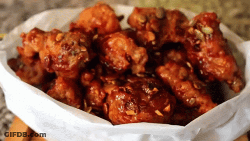A Bowl Of Fried Chicken Covered In Sauce GIF