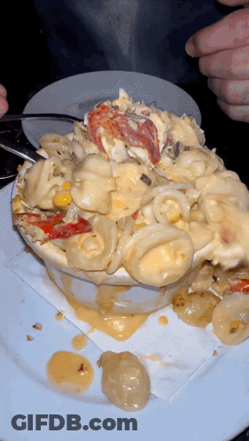 A Bowl Of Macaroni And Cheese With Lobster On Top GIF