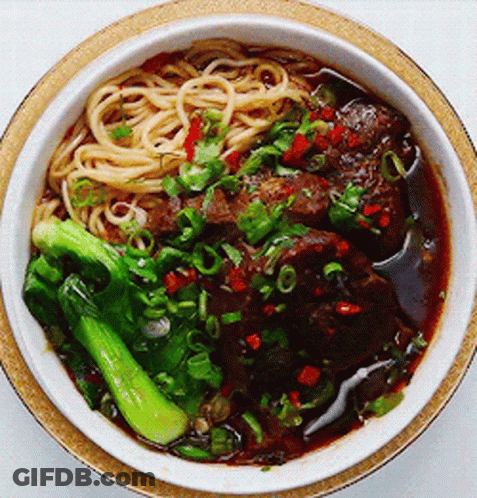 A Bowl Of Noodles With Meat And Broccoli In It GIF