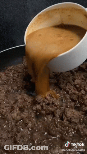 A Bowl Of Sauce Is Being Poured Into A Pan Of Ground Meat GIF