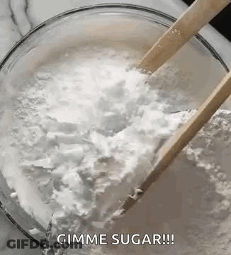 A Bowl Of Sugar With Wooden Spoons In It . GIF