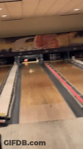 A Bowling Alley With A Painting Of A Cowboy On The Wall GIF