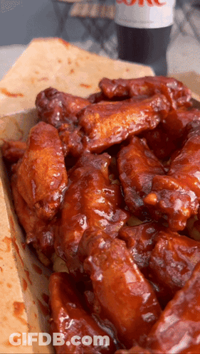 A Box Of Chicken Wings With A Coke On The Table GIF