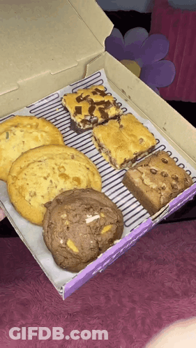 A Box Of Cookies And Brownies With A Purple Label GIF