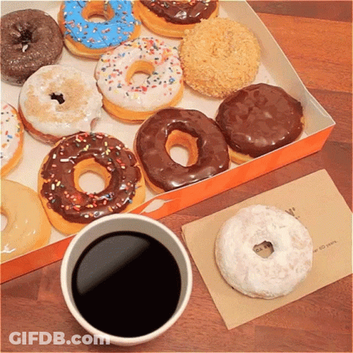 A Box Of Donuts Sits Next To A Cup Of Coffee On A Table GIF