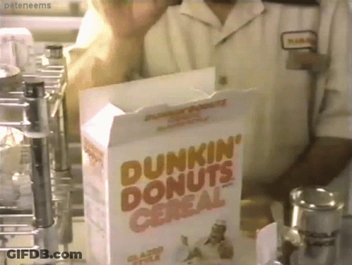 A Box Of Dunkin ' Donuts Cereal Sits In Front Of A Man GIF