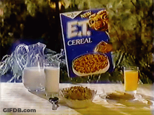 A Box Of Et Cereal Sits On A Table With A Pitcher Of Milk And A Glass Of Orange Juice GIF