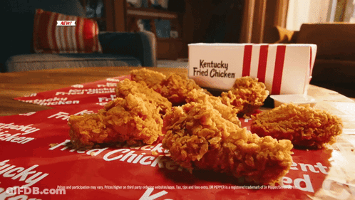 A Box Of Kentucky Fried Chicken Is Sitting On A Table GIF