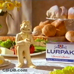 A Box Of Lurpak Butter Sits Next To A Figurine Of A Man GIF