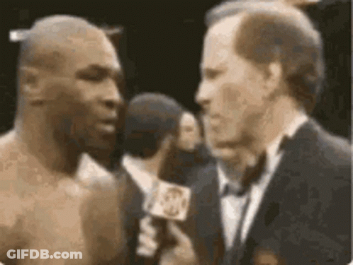 A Boxer Is Being Interviewed By A Man In A Suit And Tie . GIF