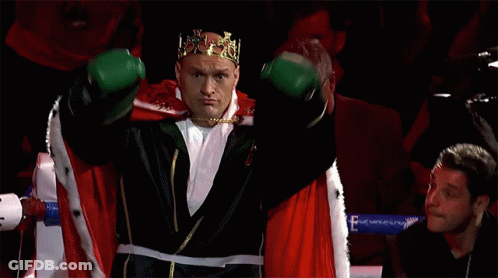 A Boxer Wearing A Crown And Green Boxing Gloves GIF