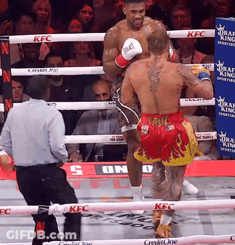 A Boxer Wearing Everlast Gloves Is Standing In A Boxing Ring GIF