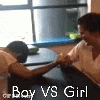 A Boy And A Girl Are Arm Wrestling Each Other . GIF
