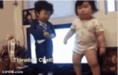 A Boy And A Girl Are Dancing In Front Of A Tv . GIF