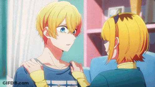 A Boy And A Girl Are Looking At Each Other And The Girl Is Holding The Boy 'S Arm GIF