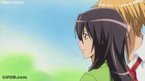A Boy And A Girl Are Looking At Each Other And The Girl Is Wearing A Green Jacket . GIF