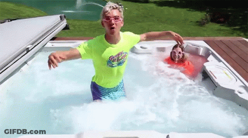 A Boy And A Girl Are Playing In A Hot Tub . The Boy Is Wearing A Neon Green Shirt . GIF