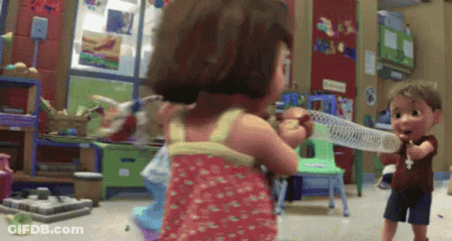 A Boy And A Girl Are Playing With A Slinky Toy In A Play Room GIF