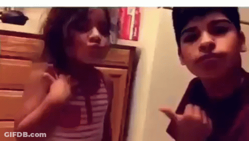 A Boy And A Girl Are Posing For A Picture Together . GIF