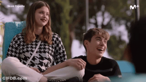 A Boy And A Girl Are Sitting Next To Each Other And The Word Espana Is On The Bottom Of The Screen GIF