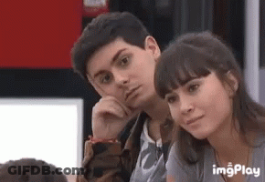 A Boy And A Girl Are Sitting Next To Each Other In A Room . GIF