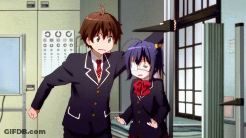 A Boy And A Girl Are Standing In Front Of A Sign That Says Tokyo Mx On It GIF
