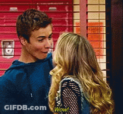 A Boy And A Girl Are Standing Next To Each Other And The Girl Has A Wow Shirt On GIF
