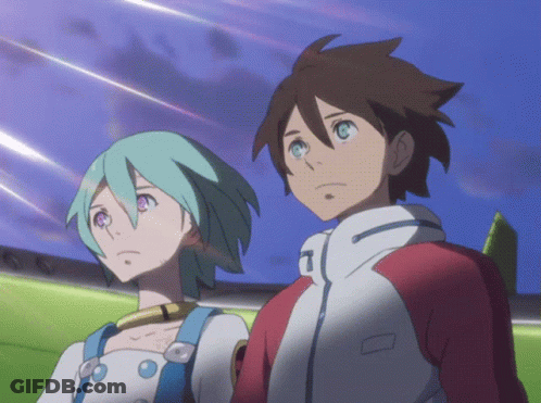 A Boy And A Girl Are Standing Next To Each Other And The Girl Has The Letter T On Her Jacket GIF