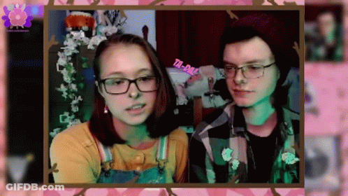 A Boy And A Girl Are Standing Next To Each Other In A Frame . GIF