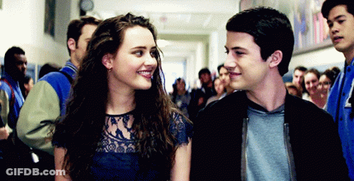 A Boy And A Girl Are Standing Next To Each Other In A Hallway . GIF