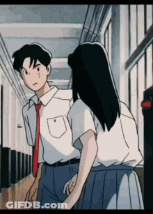 A Boy And A Girl Are Walking Down A Hallway Holding Hands . GIF