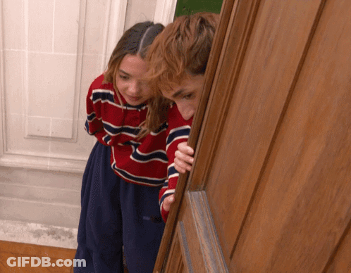 Boy And Girl Peeking Out Of Door GIF