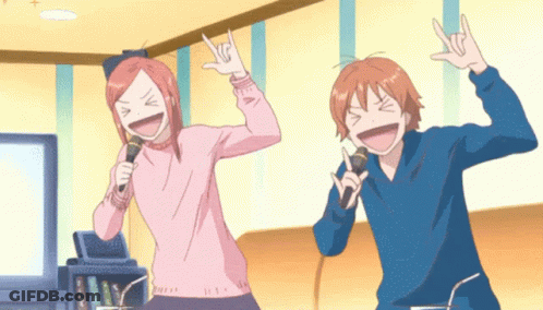 Boy And Girl Singing Into Microphones Making Rock Sign GIF
