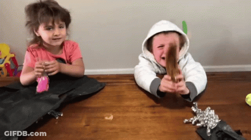 A Boy And A Girl Sitting On A Wooden Table GIF