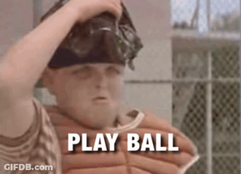 A Boy In A Baseball Uniform Is Holding His Helmet And Says Play Ball GIF