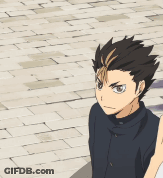 A Boy In A Black Jacket Is Standing On A Sidewalk GIF