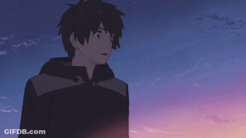 A Boy In A Black Jacket Stands In Front Of A Blue Sky GIF