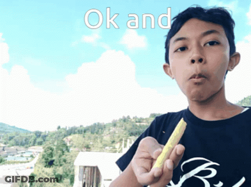 A Boy In A Black Shirt Is Holding A Yellow Object In His Hand With The Words Ok And Above Him GIF