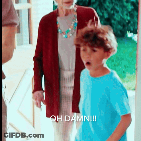 A Boy In A Blue Shirt Is Standing In Front Of An Older Woman And Says Oh Damn GIF