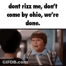A Boy In A Blue Shirt Is Talking To Another Boy In A School Hallway . GIF