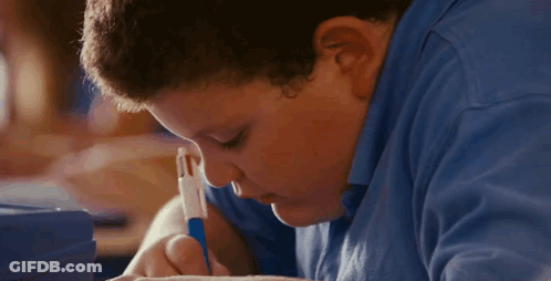 A Boy In A Blue Shirt Is Writing With A Blue Pen GIF