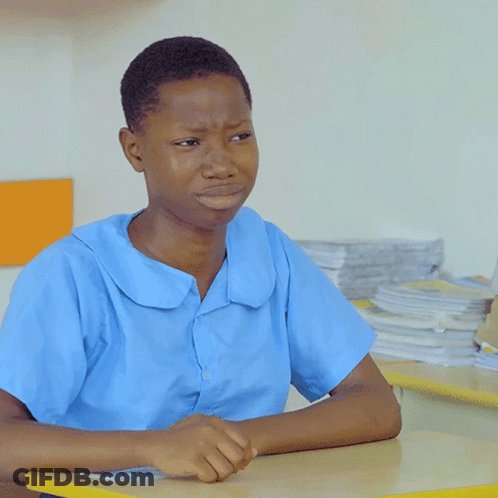 A Boy In A Blue Shirt Sits At A Table GIF