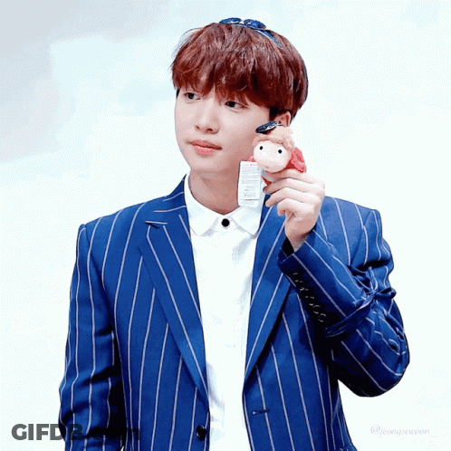 A Boy In A Blue Striped Suit Holds A Stuffed Animal GIF